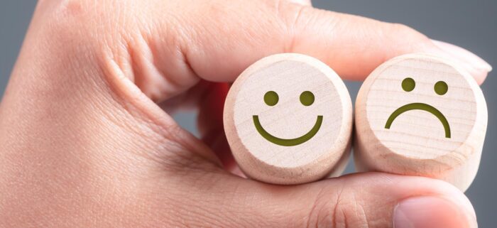 Happy and Unhappy Face on Wood Blocks, Good and Bad Feedback Concept